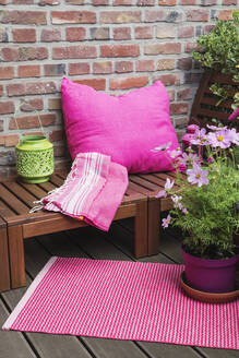 Balkon mit Bank, rosa Kissen, Decke, Laterne, Matte und verschiedenen Topfpflanzen - GWF06253