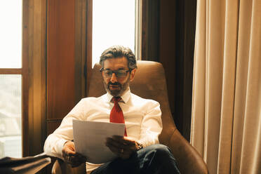 Male financial advisor reading documents at legal office - MASF14445