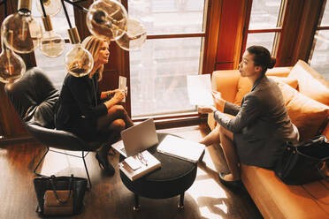 High angle view of female lawyers discussing over documents in office - MASF14472