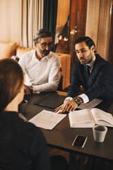 Hohe Winkel Ansicht der Mitte Erwachsenen Anwalt diskutieren über Dokumente mit Kollegen in der Sitzung im Büro - MASF14501