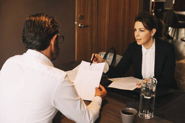 Mittlerer Erwachsener Anwalt erklärt reifem Klienten in einer Besprechung in einer Anwaltskanzlei die Dokumente - MASF14519