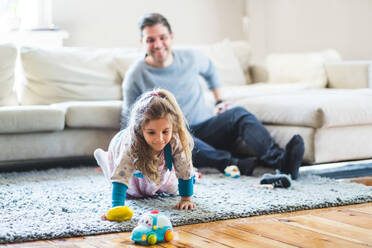 Glücklicher Mann sieht seine Tochter an, die zu Hause mit Spielzeug spielt - MASF14595