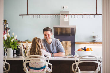 Glücklicher Vater hilft seiner Tochter beim Lernen in der Küche zu Hause - MASF14621