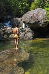 Junger erwachsener Mann beim Baden am Wasserfall des Atlantischen Regenwaldes - CAVF69064