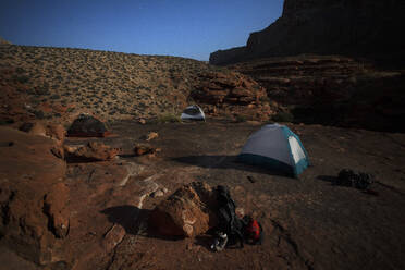 Vom Mondlicht beleuchtete Campingzelte in einer nächtlichen Felsenlandschaft - CAVF69125