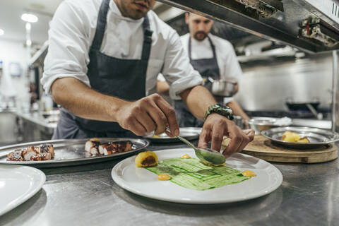 Chef garnishing plate with food stock photo