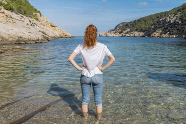 Junge Frau im Wasser am Strand stehend - AFVF04195