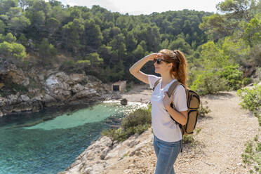 Redheaded woman standing on viewpoint and looking at distance - AFVF04197