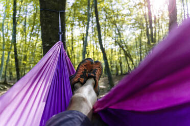 Point of view shot of man lying in hammock in a forest - GEMF03293