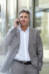 Mature businessman on the phone in the city - DIGF08873
