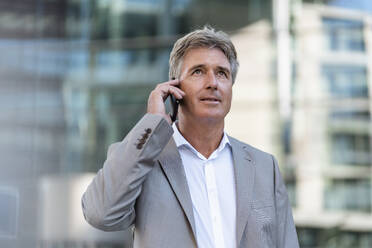 Mature businessman on the phone in the city - DIGF08874