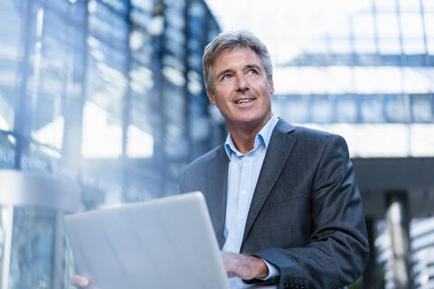 Mature businessman using laptop in the city stock photo