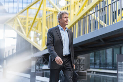 Reifer Geschäftsmann, der in der Stadt unterwegs ist, lizenzfreies Stockfoto