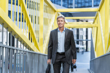 Älterer Geschäftsmann auf einer Brücke - DIGF08924