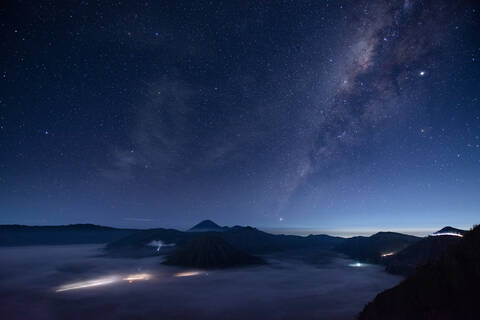 Indonesien, Ost-Java, Blick auf die Milchstraße am sternenklaren Nachthimmel über dem nebelverhangenen Mount Bromo, lizenzfreies Stockfoto