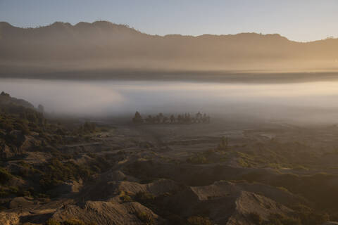 Indonesien, Ost-Java, Dichter Morgennebel über dem Tal im Bromo Tengger Semeru National Park, lizenzfreies Stockfoto