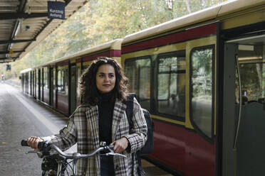 Woman with bicycle on an underground station platform, Berlin, Germany - AHSF01199