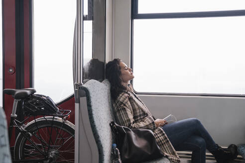 Young woman with closed eyes relaxing on a subway - AHSF01222