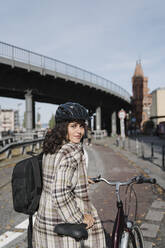 Portrait of woman with a bicycle in the city, Berlin, Germany - AHSF01224