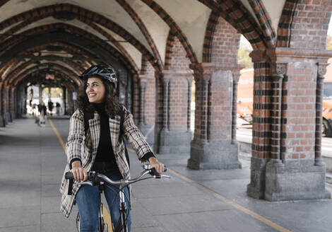 Glückliche Frau beim Fahrradfahren in der Stadt, Berlin, Deutschland - AHSF01226