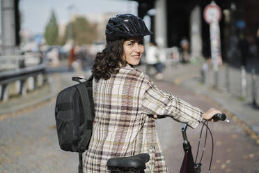 Portrait of woman with a bicycle in the city, Berlin, Germany - AHSF01254
