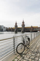 Abgestelltes Fahrrad mit der Oberbaumbrücke im Hintergrund, Berlin, Deutschland - AHSF01259