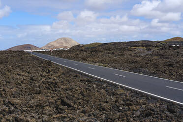 Spanien, Kanarische Inseln, Lanzarote, Mancha Blanca, Landstraße über Lavafeld - SIEF09290