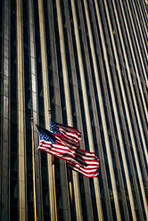 USA, New York, New York City, Three American flags against skyscraper - OCMF00890