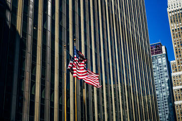 USA, New York, New York City, Three American flags against skyscraper - OCMF00891