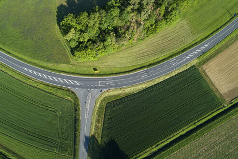 Deutschland, Bayern, Luftaufnahme von grünen Feldern entlang einer Landstraße im Frühling - RUEF02378