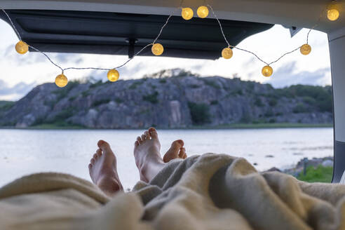 Feet of teenage couple, lying in a camper at the sea - LBF02790