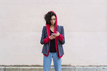 Porträt einer jungen Frau, die ein Mobiltelefon im Freien benutzt - ERRF02040