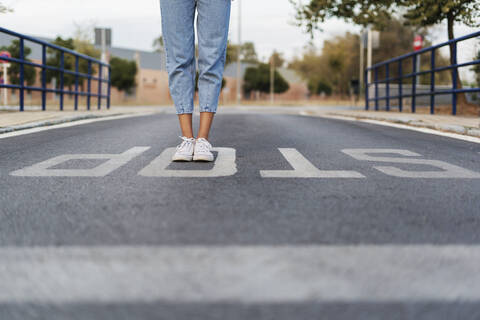 Crop-Ansicht einer jungen Frau, die auf der Straße auf dem Wort 