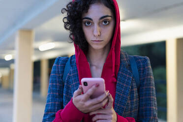Portrait of young woman with mobile phone in the evening - ERRF02061