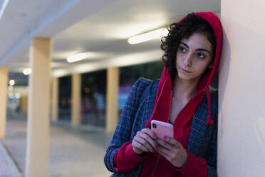 Portrait of young woman with mobile phone in the evening - ERRF02065