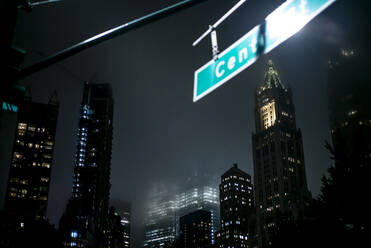USA, New York, New York City, Straßennamenschild vor beleuchteten Wolkenkratzern bei Nacht - OCMF00909