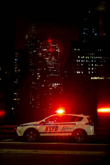 USA, New York, New York City, NYPD-Nachtstreifenwagen mit eingeschalteten Notleuchten - OCMF00912