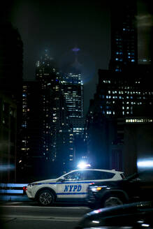 USA, New York, New York City, NYPD-Nachtstreifenwagen mit eingeschalteten Notleuchten - OCMF00913