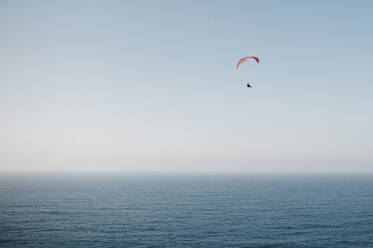 Person beim Gleitschirmfliegen über dem Meer - CAVF69256