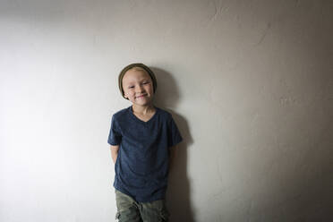 Porträt eines Jungen, der zu Hause an der Wand steht - CAVF69264