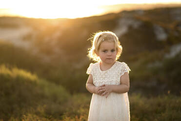 Porträt eines süßen Mädchens auf einem Feld stehend - CAVF69271
