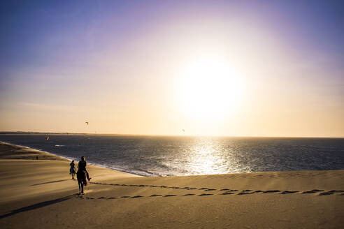 Silhouette Menschen Reiten am Ufer am Strand gegen dramatischen Himmel - CAVF69310