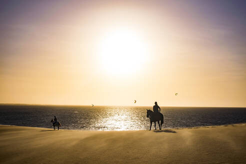 Silhouette Menschen Reiten am Ufer am Strand gegen Himmel - CAVF69311