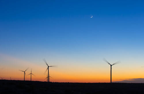 Silhouette Windräder drehen sich gegen den blauen Himmel bei Sonnenuntergang - CAVF69337