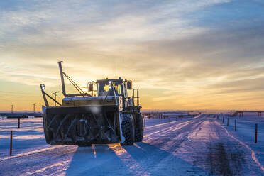 Snowblower at field against dramatic sky during sunset - CAVF69349