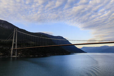 Unter der riesigen Hardangerbrücke hindurch, Sonnenaufgang, schöne Morgenwolken, Hardangerfjord, Norwegische Westfjorde, Norwegen, Skandinavien, Europa - RHPLF12805