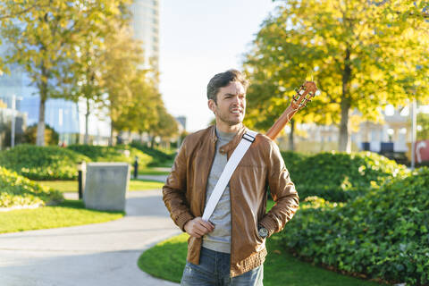 Mann in einem Stadtpark mit Gitarre, Madrid, Spanien, lizenzfreies Stockfoto