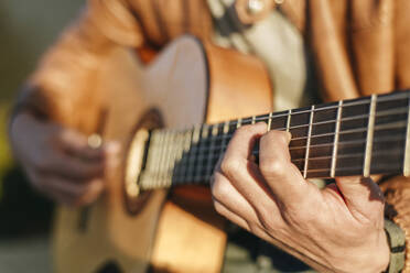 Nahaufnahme eines Gitarre spielenden Mannes - KIJF02771