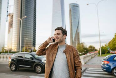 Happy man on the phone in the city, Madrid, Spain - KIJF02787