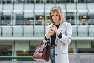 Frau benutzt Mobiltelefon in der Stadt - KIJF02812